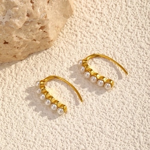 Elegant gold titanium steel hoop earrings with six white pearls in a minimalist design
