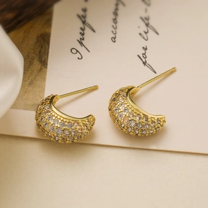 Elegant 18K gold-plated C-shaped earrings with micro-paved crystals on an aesthetic card