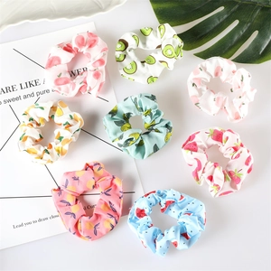 Flat lay detail of colorful fruit pattern scrunchies including strawberry and avocado designs