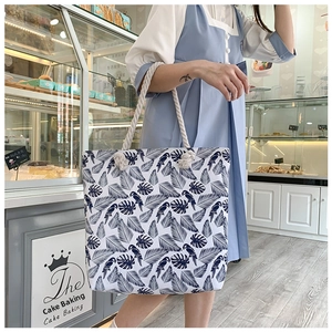 Floral canvas tote bag featuring tropical leaf and parrot prints with rope handles