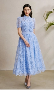 Close-up of light blue lace dress featuring ruffled collar and bubble sleeve details
