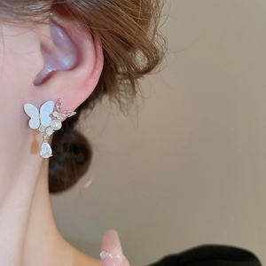 Detail showing pearl butterfly earrings with pink crystal and zircon drop pendant