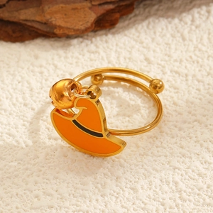 Detalle macro de anillo abierto dorado con dijes de sombrero de bruja naranja y cascabel