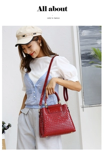 Detail of red patent leather tote bag with woven texture and gold hardware on model