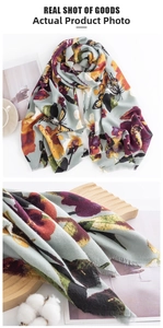 Close-up of butterfly and floral print cashmere feel scarf with delicate fringe edges