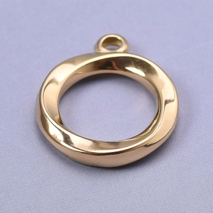 Detailed view of a golden twisted round pendant with polished finish for DIY jewelry