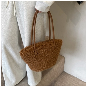 Détail du sac à main en fausse fourrure marron avec poignée en cuir perlée chic