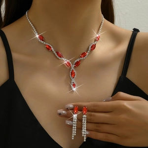 Detail of red rhinestone bridal necklace and tassel earrings set on a model