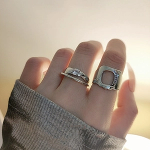 Close-up of sparkling cubic zirconia rings on model's hand with warm lighting