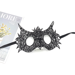 Detail of black lace masquerade mask with intricate cutout patterns and ribbon ties