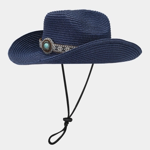 Detail of dark blue straw cowboy hat with turquoise ethnic band and adjustable chin strap