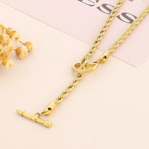 Collana a catena in acciaio al titanio dorato con chiusura a cuore su sfondo rosa