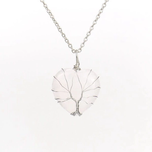 Detail of silver wire wrapped pink rose quartz heart tree of life pendant on a silver chain