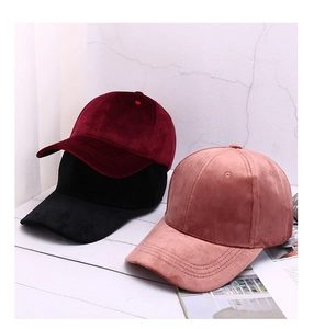 Close-up detail of velvet baseball caps in burgundy, black and dusty pink colors