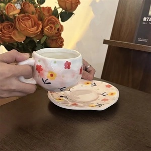 Detailed view of hand-painted floral ceramic coffee cup set with matching saucer
