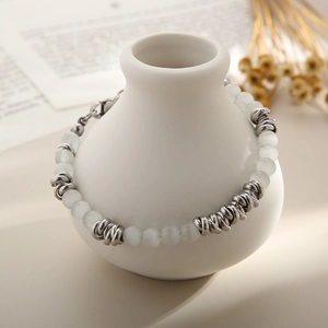 Détail du bracelet bohème avec perles œil de chat blanches et anneaux en argent