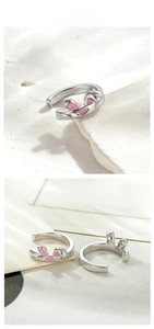 Detail of bunny ear ear cuff with pink enamel finish on a minimalist stone background