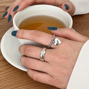 Set of 925 sterling silver rings with heart charm and quilted pattern on hand