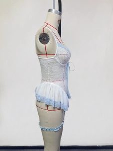 Detailed shot of white lace lingerie with blue bow and tiered chiffon hemline