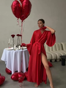 Detailed close-up of luxurious red satin robe with silky texture and tie waist belt