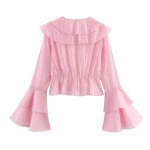 Détail du chemisier en mousseline rose avec col à volants et manches cloches doubles