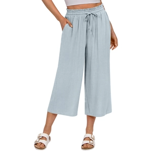 Detail of light blue linen-textured pants featuring elastic drawstring waist and side pockets