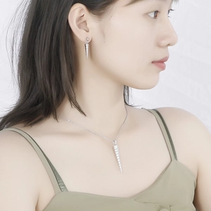 Silver stainless steel jewelry set with threaded cone pendants on a female model