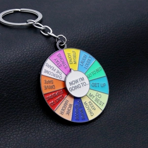 Close-up of a rainbow enamel decision maker keychain with rotating motivational phrases