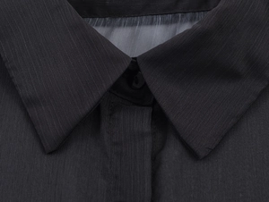 Primo piano del colletto di una camicia nera in chiffon con risvolto e bottone nero