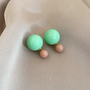 Detail of mint green and pale pink resin double ball earrings with silver needle post