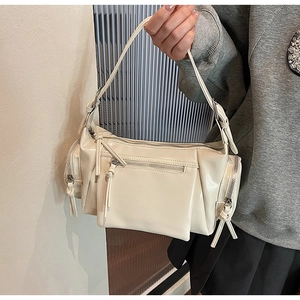 Gros plan d'un sac crème en simili cuir délavé avec fermetures éclair et texture brillante