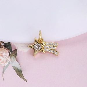 Macro shot of gold star-shaped pendant with clear crystal inlay on a white ceramic plate