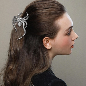 Detail of silver spider hair claw clip made of metal worn on hair for Halloween