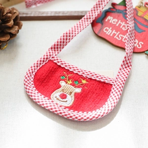 Close-up of red felt Christmas dog bandana with reindeer embroidery and pine cones
