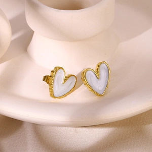 Close-up of heart earrings with gold wavy frames and smooth white enamel filling