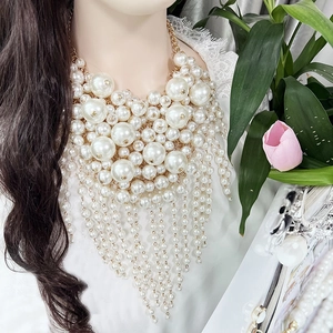 Detailed view of layered white imitation pearl fringe necklace on jewelry bust display