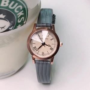 Detail of rose gold case with champagne Roman dial and grey leather strap of the watch