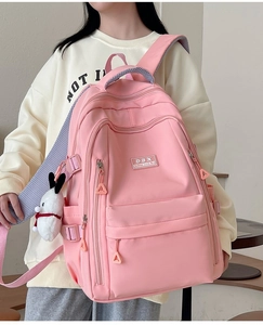 Detailed shot of pink waterproof nylon backpack with a cute rabbit pendant and side buckles