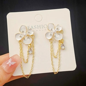 Detailed shot of white floral tassel earrings with pearls and crystals on jewelry card