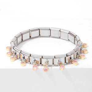 Silver stainless steel bracelet with golden charms and pink gemstones on white block