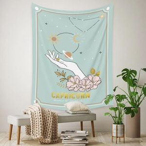 Detail of Capricorn zodiac wall tapestry with gold foil lettering and bohemian floral decor