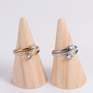 Elegant spiral rings in gold and silver finish with zircon stones on wooden stands