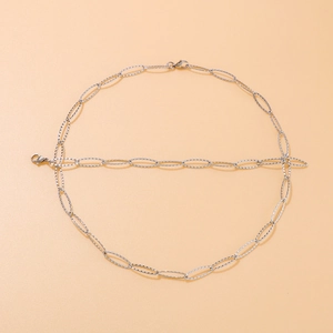 Sparkling silver stainless steel necklace set with oval textured links on beige background