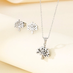 Detailed view of silver stainless steel necklace and earrings with hollow tree of life motif