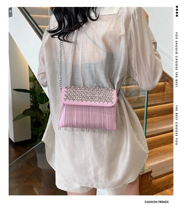Detail of pink crossbody bag featuring sparkling rhinestones and long metallic fringe tassels
