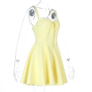 Gros plan d'une mini robe jaune à bretelles avec bordure en dentelle et nœud délicat