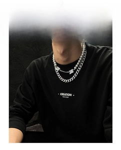 Détail d'un collier multicouche en argent à maille cubaine et perles porté par un mannequin