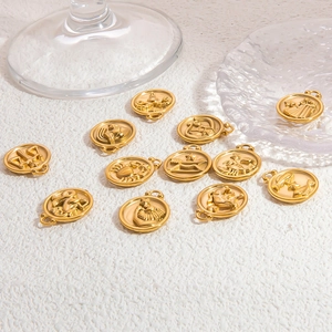 Golden zodiac sign pendants made of stainless steel displayed on a white textured background