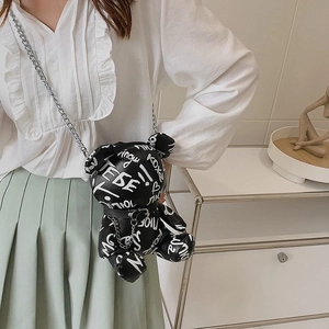 Graffiti bear shaped crossbody bag with silver chain strap shown in lifestyle shot