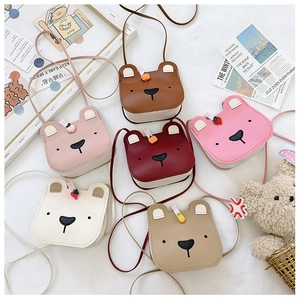 Group display of colorful cartoon bear crossbody bags with fruit accents and shoulder straps